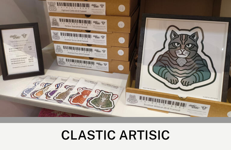 Clastic Artistic Images: A retail display of Scottish Mammal products. There are stickers to the left and a framed Scottish Wildcat print to the right. Text: Clastic Artistic ©Clastic Artistic